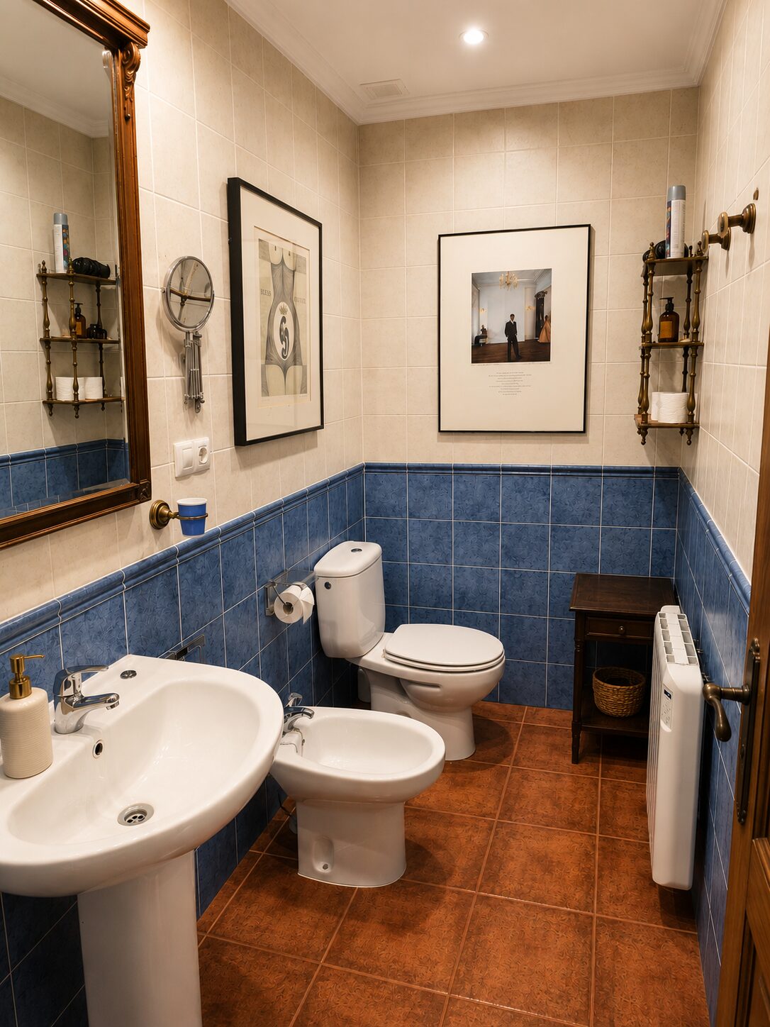 Baño de la habitación Presencia — lavabo, espejo dorado y obra enmarcada